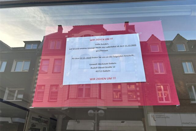 Ein Schild weist auf den Umzug eines Geschäfts hin.