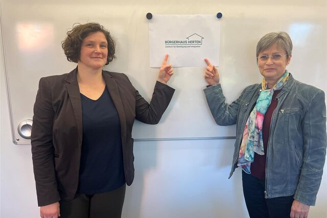Stefanie Hasler und Christiane Rohde zeigen auf das Logo des Bürgerhaus Herten.