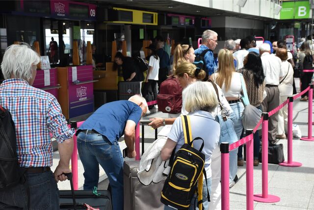 Menschen in der Check-in-Schlange am Flughafen in Dortmund.