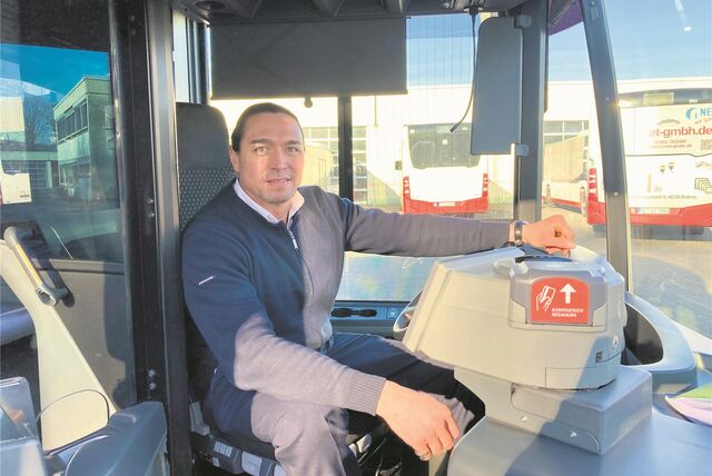 Busfahrer Ismail Baser auf dem Fahrersitz seines Busses.