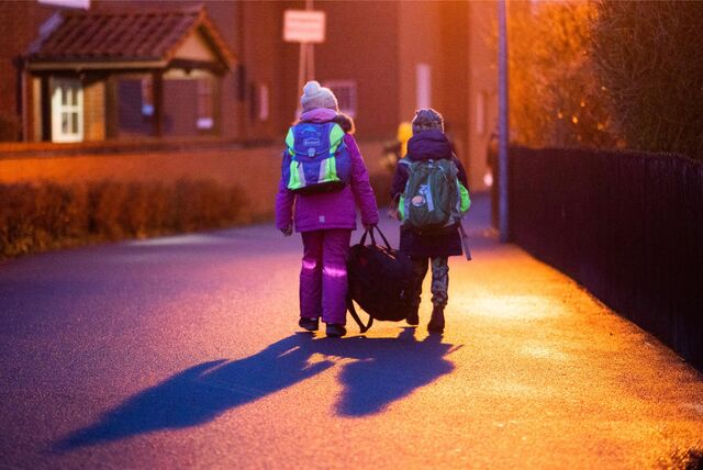 Zwei Schulkinder laufen einen Weg entlang.