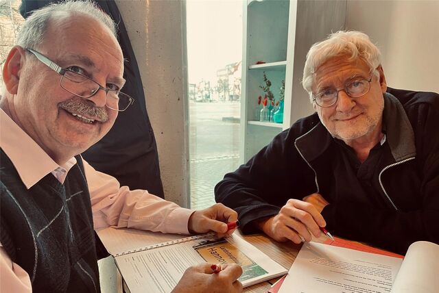 Heinz-Bernd Einck und Ulrich Engelmann arbeiten mit Stiften in der Hand am Programm der „Närrischen Ratssitzung“.