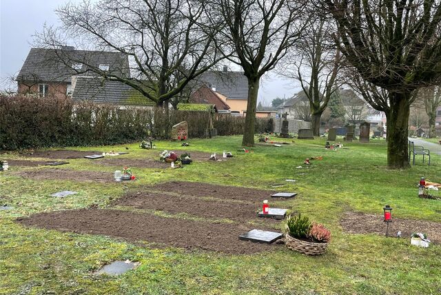 Blick auf einen Friedhof mit Rasengräbern