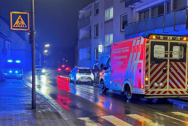 Ein Krankenwagen parkt hinter einem weißen Pkw. Auf der gegenüberliegenden Straßenseite steht ein Notarztwagen mit eingeschaltetem Blaulicht.