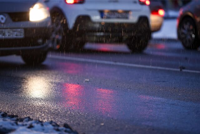 Autos fahren über eine glatte Straße bei leichtem Schneefall