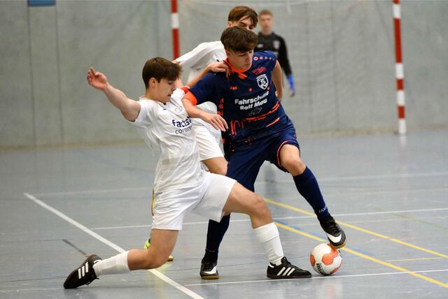 Zwei Jugendfußballer im Duell um den Ball bei einem Hallenturnier.