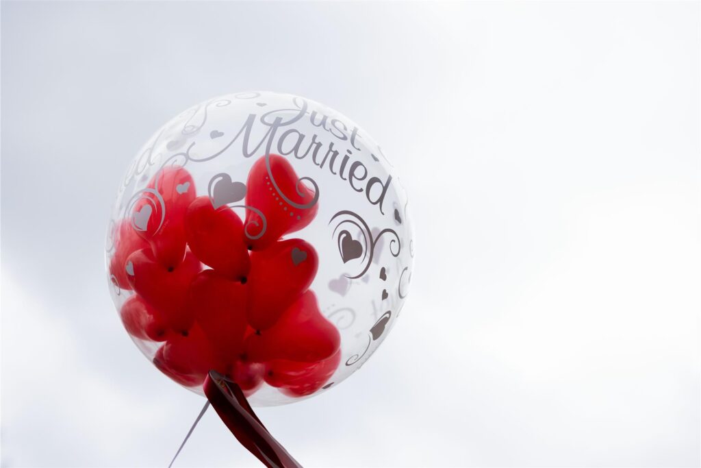 Ein Ballon mit der Aufschrift Just Married ist gefüllt mit weiteren kleinen herzförmigen Ballons.