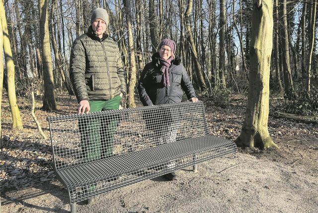 Grünpflegerin Claudia Ritzmann und Thomas Thiedig von der Waltroper Garten- und Landschaftsbaufirma stehen hinter einer der neuen Bänke im Zechenwald im Osten Waltrops.