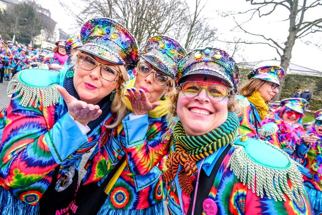 Drei verkleidete Frauen schicken Handküsse in die Kamera auf dem Rosenmontagszug in Recklinghausen