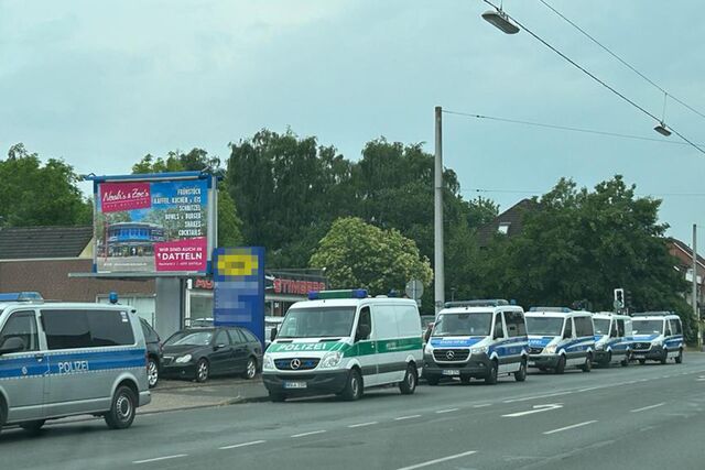 Einsatzwagen der Polizei stehen vor einem Kfz-Betrieb in Oer-Erkenschwick am Straßenrand.