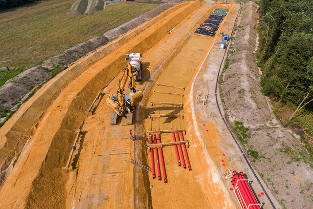 Baustelle für eine Stromtrasse mit Bagger und Leerrohren