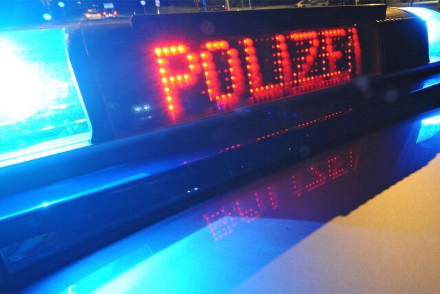 Die eingeschaltete Leuchtschrift eines Polizeiautos.