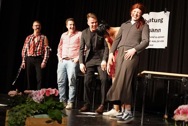 Auf der Bühne der Stadthalle Waltrop stehen fünf zum Teil verkleidete junge Männer und lachen.