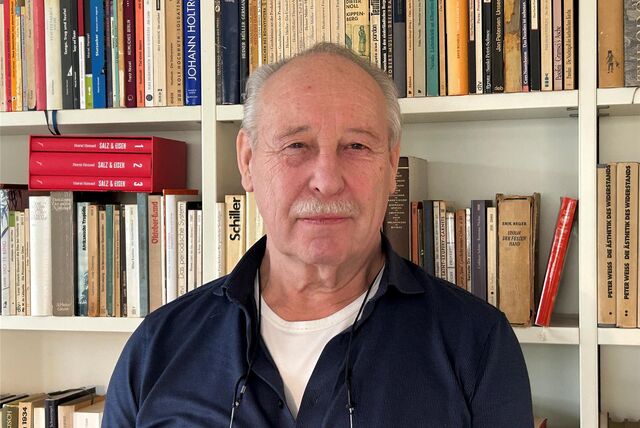 Horst Hensel vor einer Bücherwand.