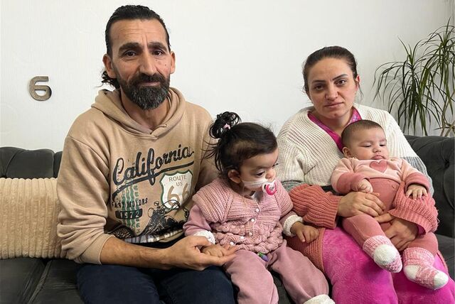 Eine Familie sitzt auf einem Sofa.