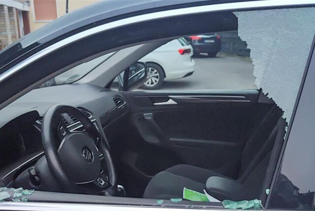 Die eingeschlagene Fensterscheibe auf der Fahrerseite eines Autos.
