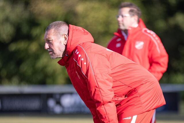 Burghard Bachmann steht gebeugt am Spielfeldrand.