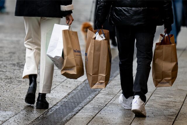 Zwei Passanten laufen mit Tüten in den Händen am verkaufsoffenen Sonntag durch die Innenstadt.