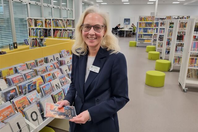 Silke Hilse, neue Leiterin der Stadtbibliothek Recklinghausen, steht neben Bücherregalen.