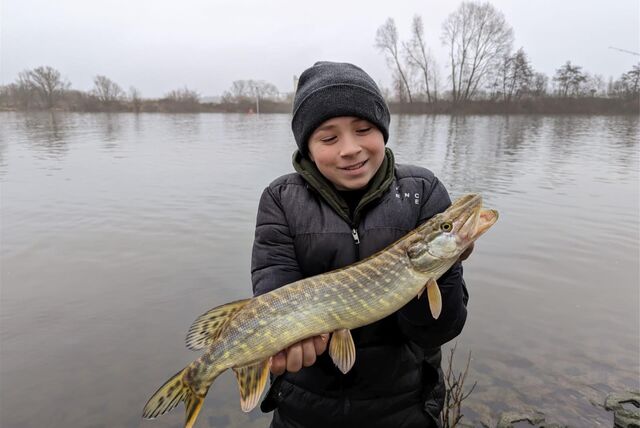 Ein Kind hält einen Fisch im Arm.