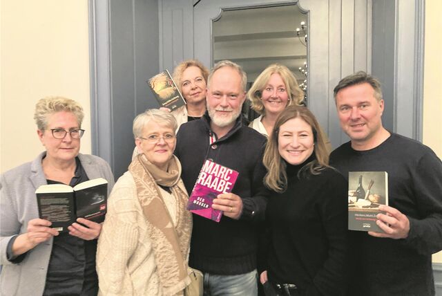 Sechs Menschen rund um den Bestseller-Autor Marc Raabe mit Büchern in der Hand.