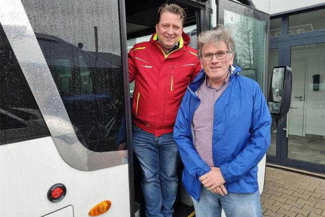 Zwei Männer stehen in der Eingangstür eines Busses.