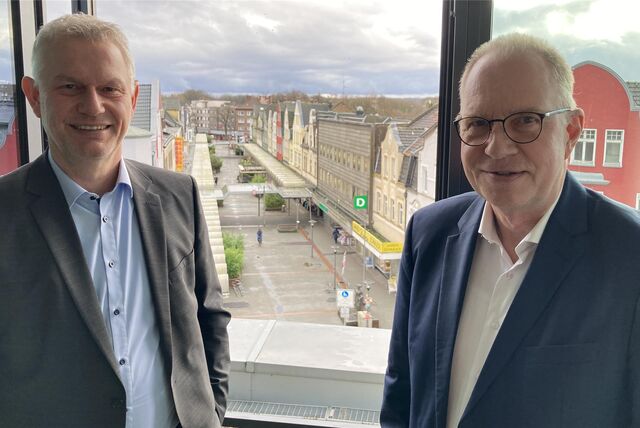 Mit Blick auf die Fußgängerzone Hülsstraße in Marl präsentieren die Vorstände Olaf Kilimann (r.) und Andreas Geilmann-Ebbert starke Zahlen aus der Jahresbilanz 2023 der Volksbank Marl-Recklinghausen.