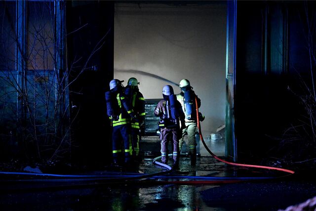 Vier Feuerwehrleute löschen das Feuer in einer Lagerhalle am Bruchweg in Recklinghausen.