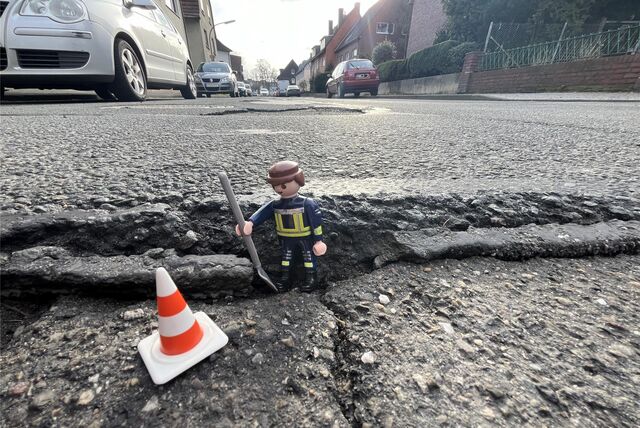 Ein Playmobil-Männchen steht in einem Schlagloch