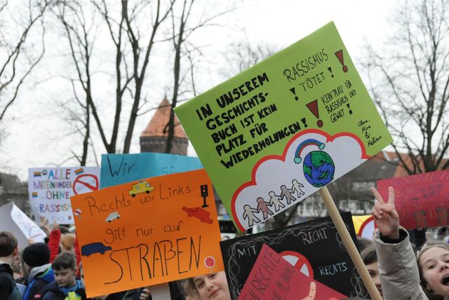 Die Schüler der weiterführenden Schulen halten Protestplakate in die Höhe.