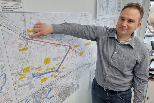 Ein Mann zeigt auf einen Bauplan.