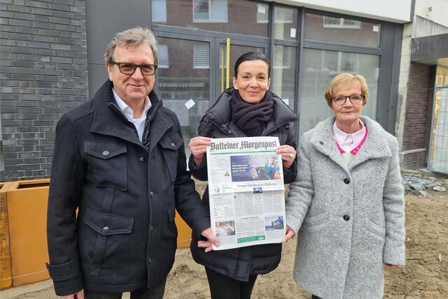Zwei Frauen und ein Mann stehen auf einer Baustelle.