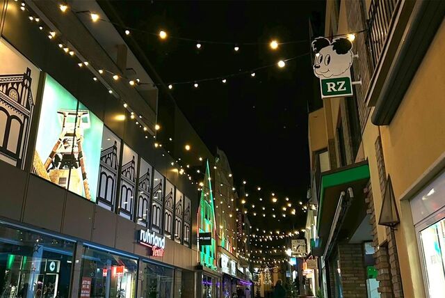 Zwischen den Häusern sind Lichterketten gespannt, dessen LED-Birnen die Fußgängerzone erhellen.