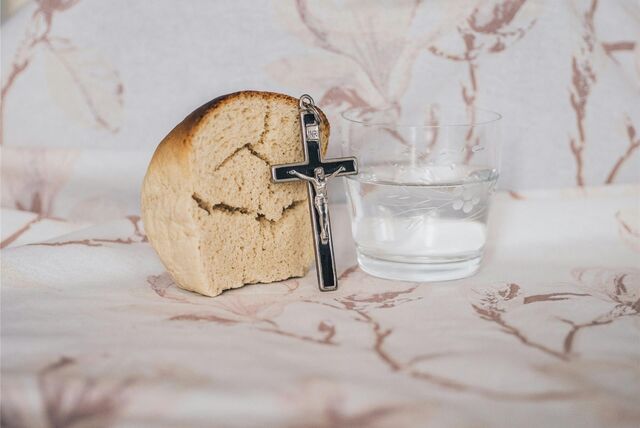 Ein Stück Brot, ein Kruzifix und ein Glas Wasser als Symbol für die Fastenzeit.