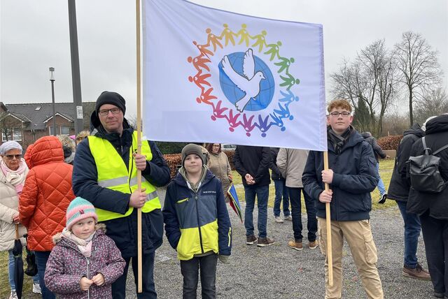 Christoph Weber und seine Kinder Laura (7), Jonas (11) und Philip (14) sind mit einem großen Friedensbanner zur Mahnwache gekommen.