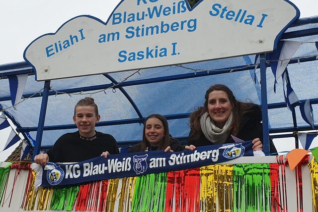 Drei Personen stehen auf einem Karnevalswagen