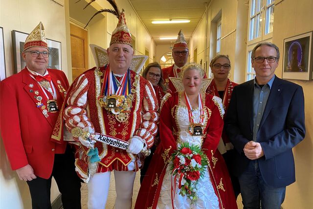Menschen stehen in Karnevalskostümen auf dem Flur des Dattelner Rathaus neben dem Bürgermeister.