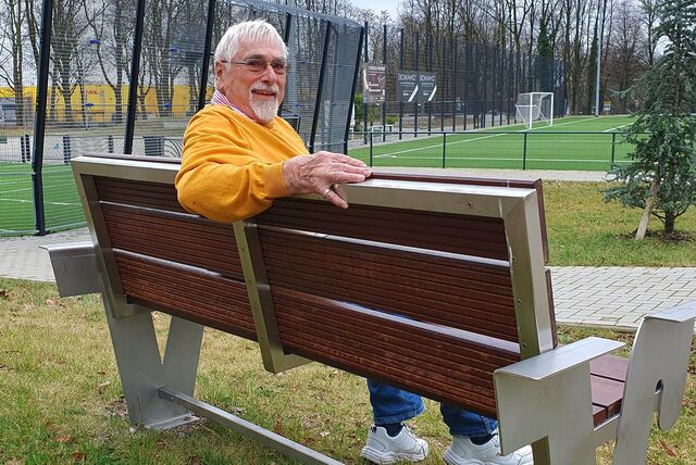 Ein mann sitzt auf einer Bank