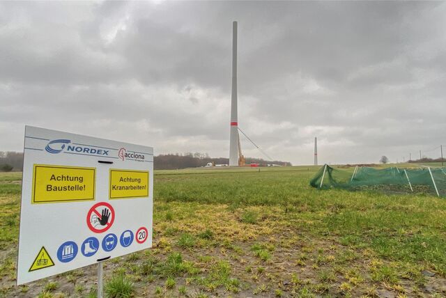 Auf einem Feld steht der Turm für ein neues Windrad.