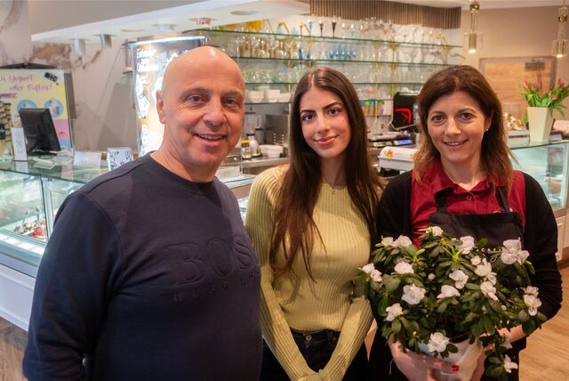 Zwei Frauen und ein Mann stehen vor einer Eistheke.