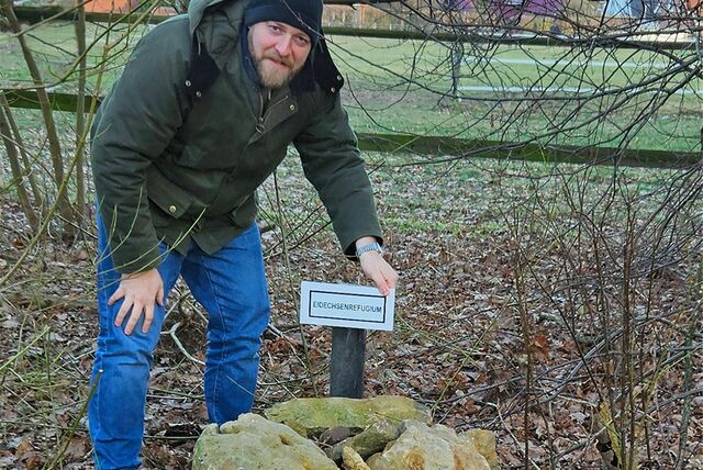 Max Dreckmann mit Schild „Eidechsenrefugium“
