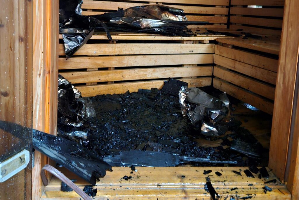Blick in die Sauna mit verkohlten Resten. Blick in die Sauna mit verkohlten Resten.