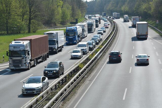 Autos und Lkw stauen sich auf einer Autobahn.