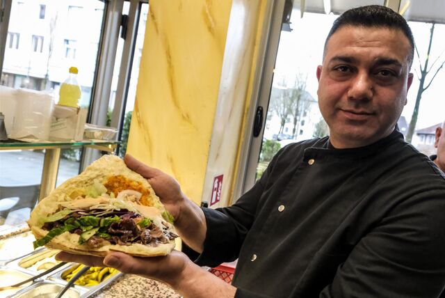 Ercan Kerekli, Inhaber des Boğaziçi-Restaurants in Recklinghausen, hält eine Dönertasche in den Händen.