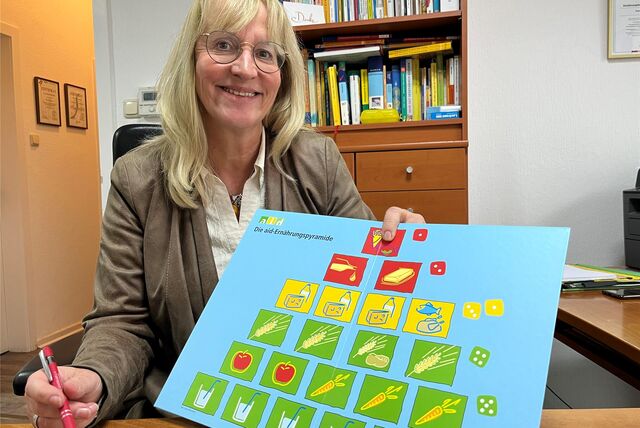 Birgit Brusdeilins zeigt ein Modell der Ernährungspyramide, viel Wasser, Obst und Gemüse bilden die Basis.