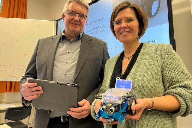 Sascha Maurus und Yvonne Jeschke stehen vor einem digitalen Whiteboard.