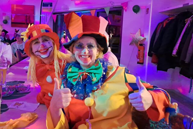 Zwei Clowns lachen in die Kamera.