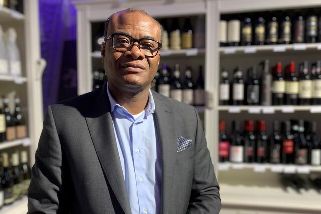 Pierre Scheeper steht vor einem Weinregal in seiner „Wein- & Genusswelt“ auf dem Hof Schulte-Rauxel.