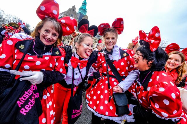 Mitglieder der Altstadtblüten feiern als Minnie Maus verkleidet auf dem Rosenmontagszug in Recklinghausen