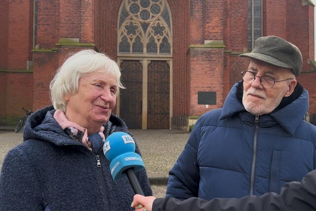 Eine Frau und ein Mann werden vor der Kirche in Haltern interviewt.